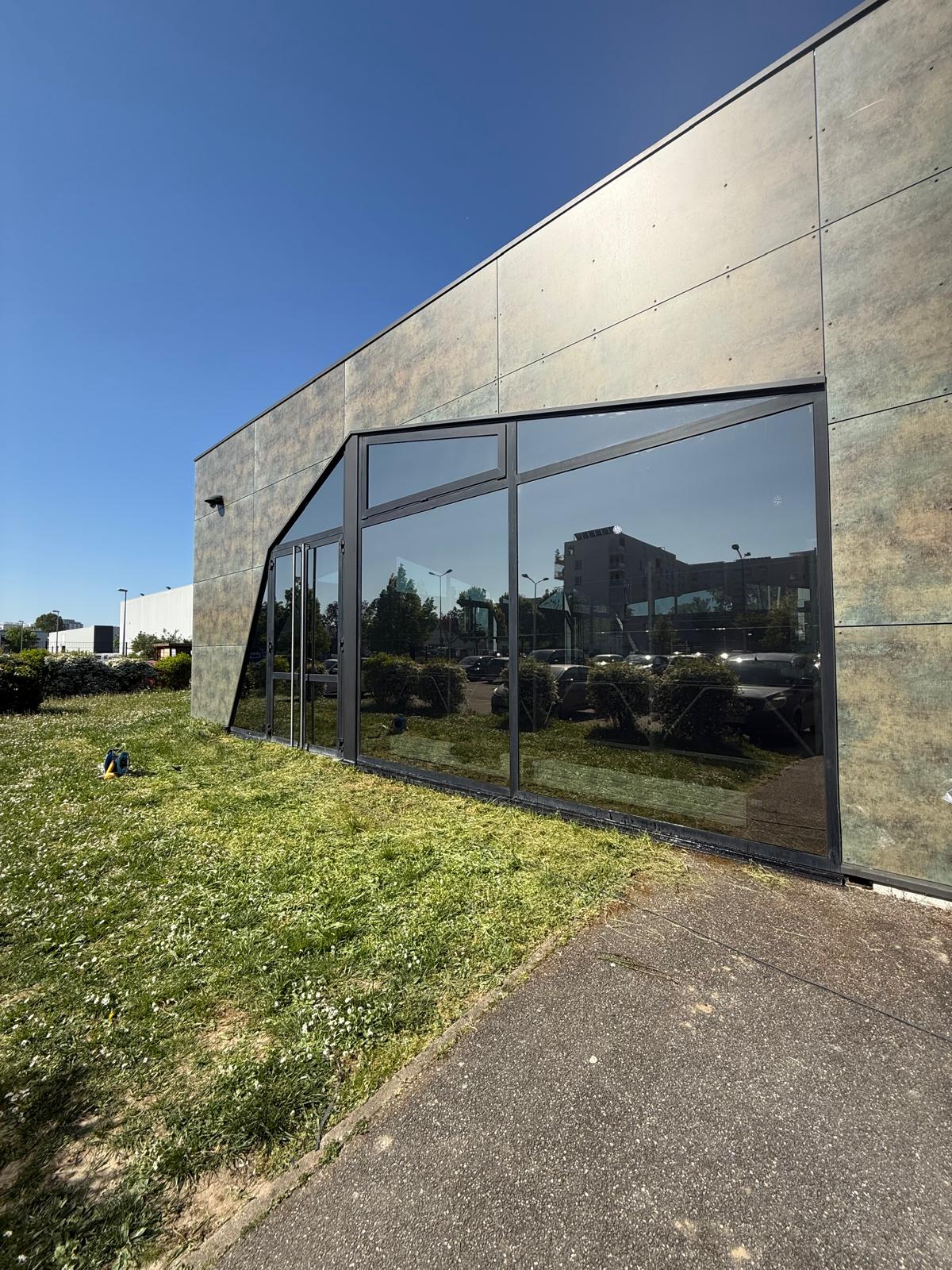 Découpe, pose et application de films de protection antichaleur sur les vitres du centre de cours collectifs One Fitness à Strasbourg Neudorf, proche du Port du Rhin.