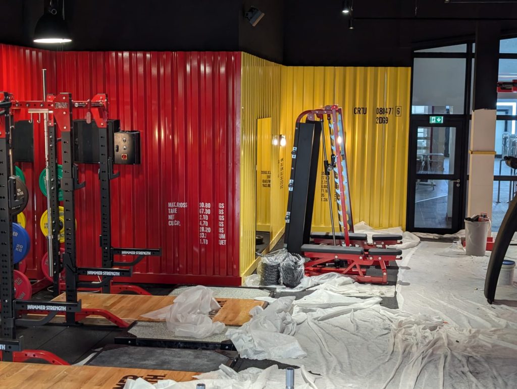 Création, impression et pose d’un habillage décoratif sur les façades intérieures pour la salle de sport One Fitness Est à Strasbourg Neudorf, proche de la place de l’Étoile.